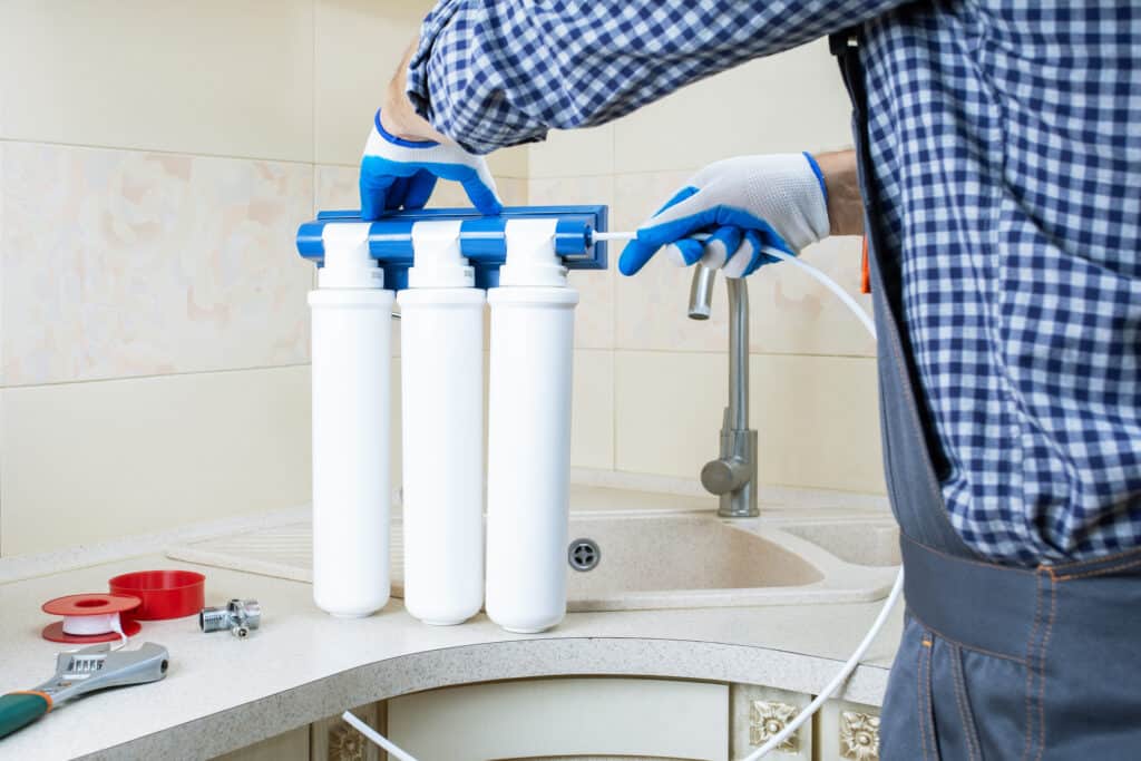 A plumber installs water filtration systems.